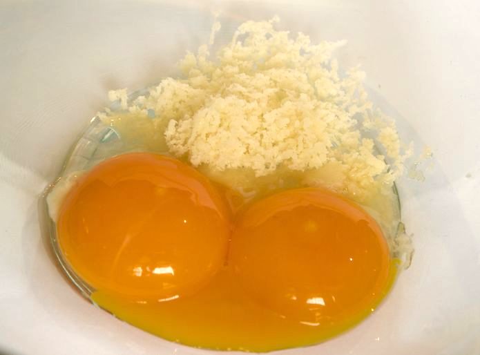 Egg yolks with grated palm sugar. Note that the photo shows only half of the yolks and sugar called by the recipe.